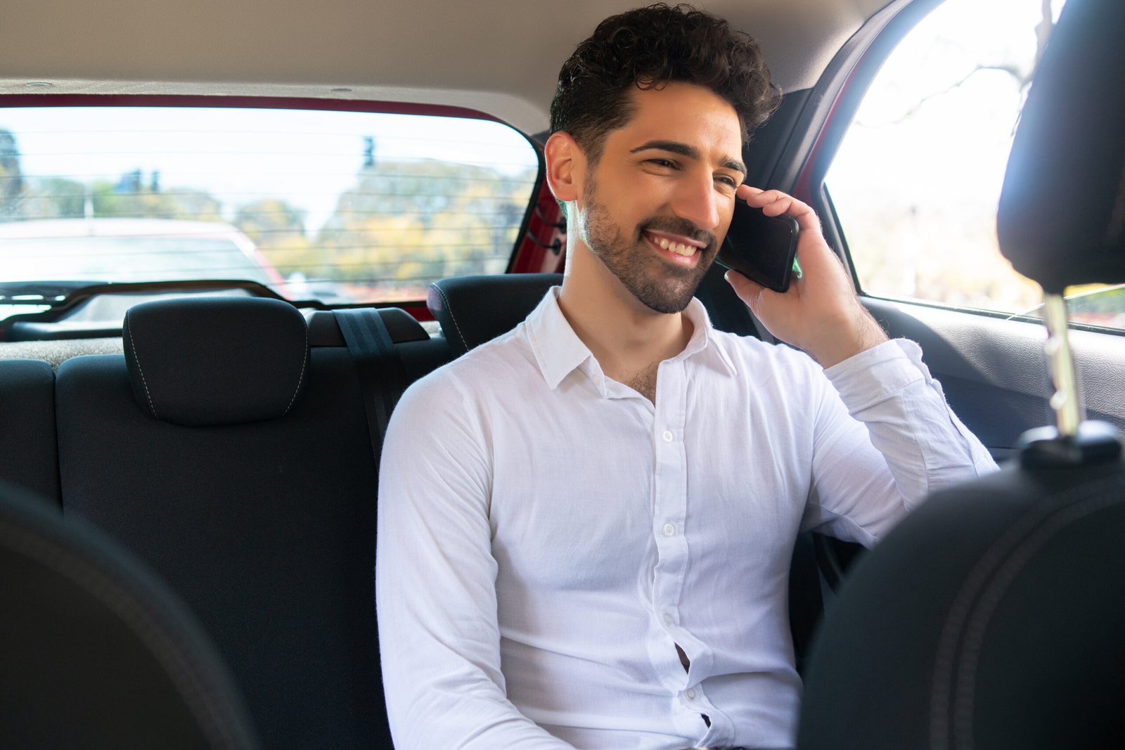 Businessman talking on phone in car.